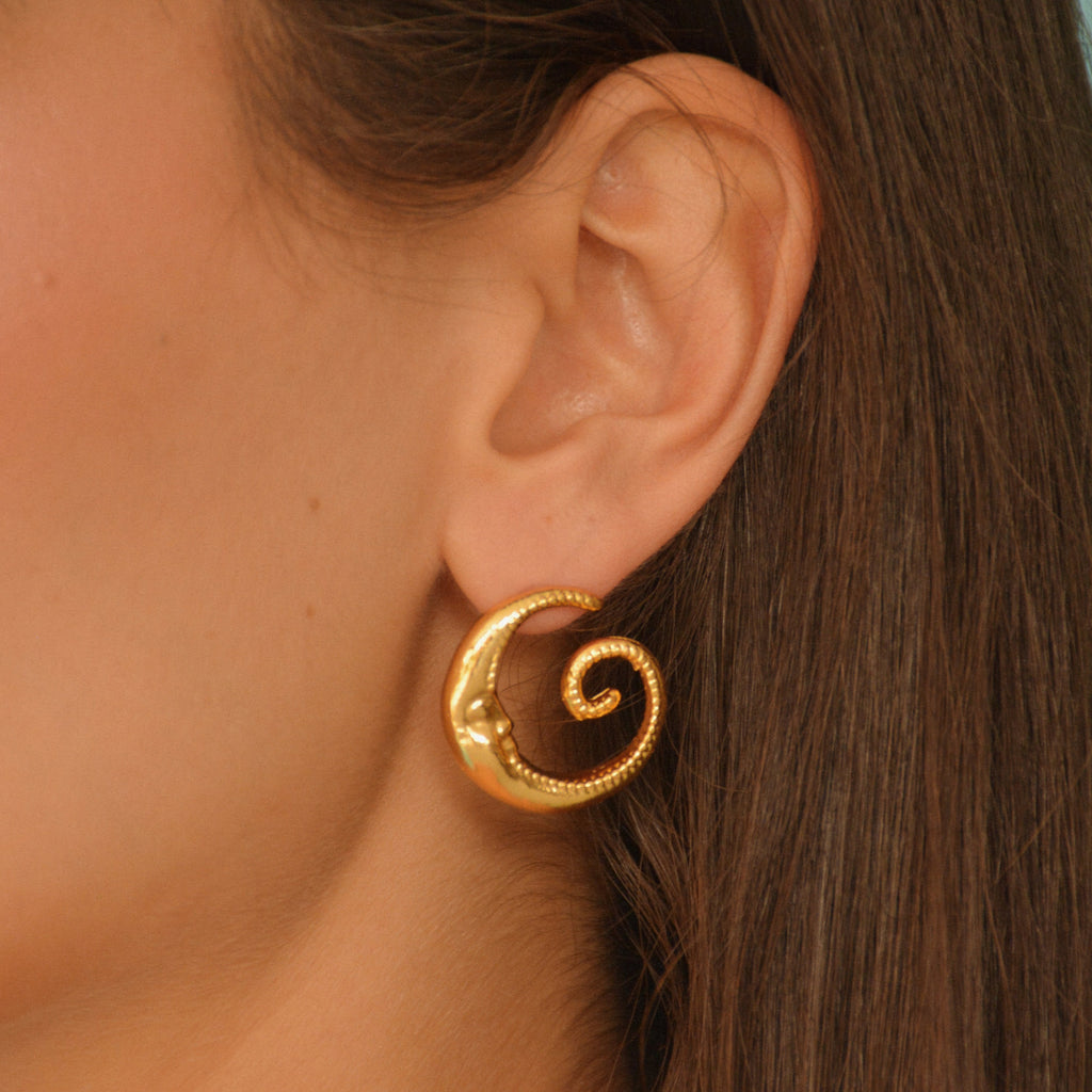 Aretes tipo topo Mooncy con acabado dorado en baño de oro de 24K.